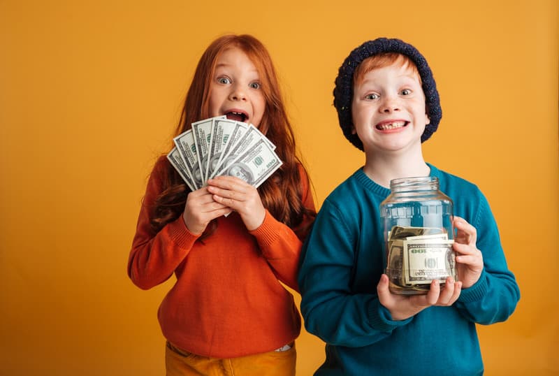 A young boy and girl are excited after seeing how much money they've saved in their piggy bank.