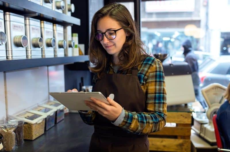 A female business owner reviewing her business inventory to prepare her "cost of goods sold" for her yearly business taxes