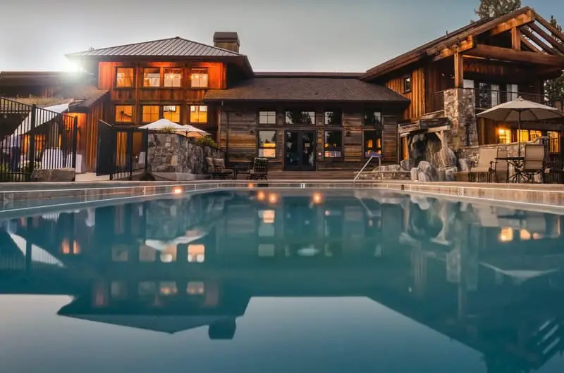 The view of a beautiful million-dollar home and a large pool in the backyard.