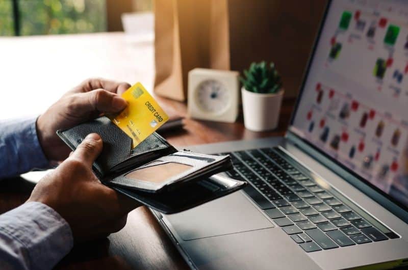 A young man is shopping online on his laptop. E-commerce is a booming business to be in these days.