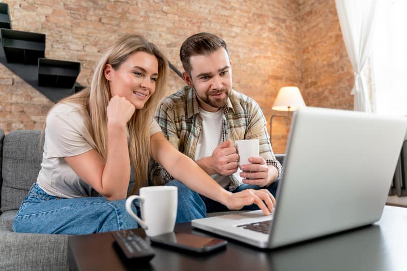 A couple are working together on their laptop, to manage their personal finances like a business.