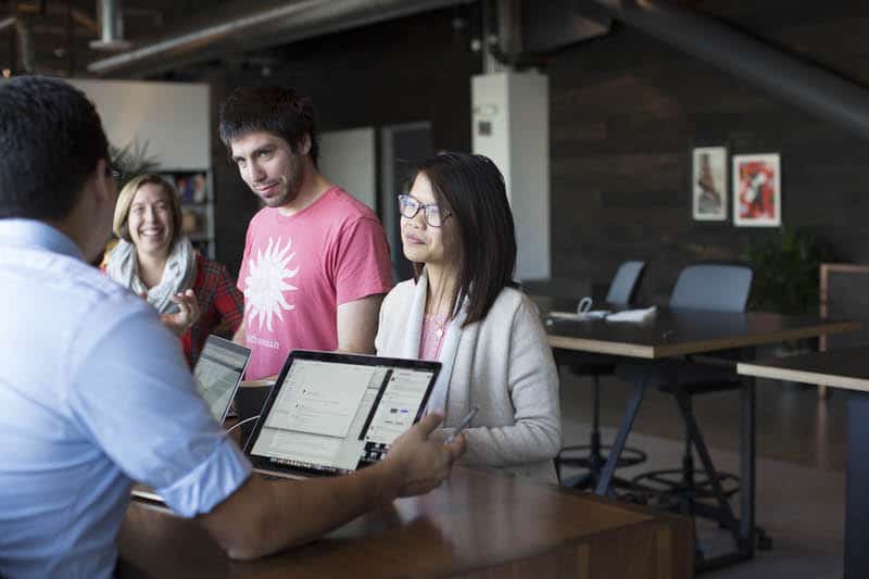 Stripe employees are discussing their project work with each other.