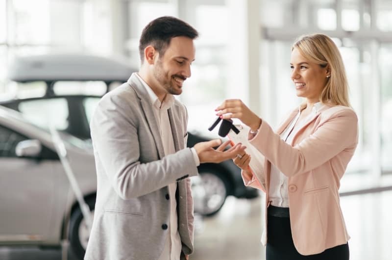 Mom just bought a car for her son, and is giving him the keys to it at the dealership. This entitlement is making the son lazy.