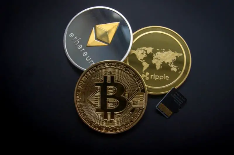 A visual of a physical bitcoin, ripple coin, and ethereum coin.