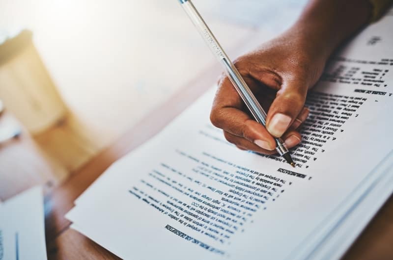 A young woman is reviewing the extensive fine print after verbally agreeing to hire her financial advisor.