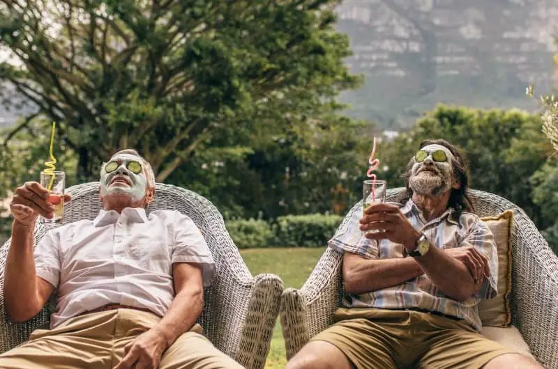 Two retired friends are at a spa, relaxing and enjoying a drink.