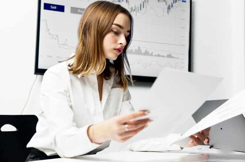 A young investor is looking at her notes, reviewing for a potential stock market correction soon.