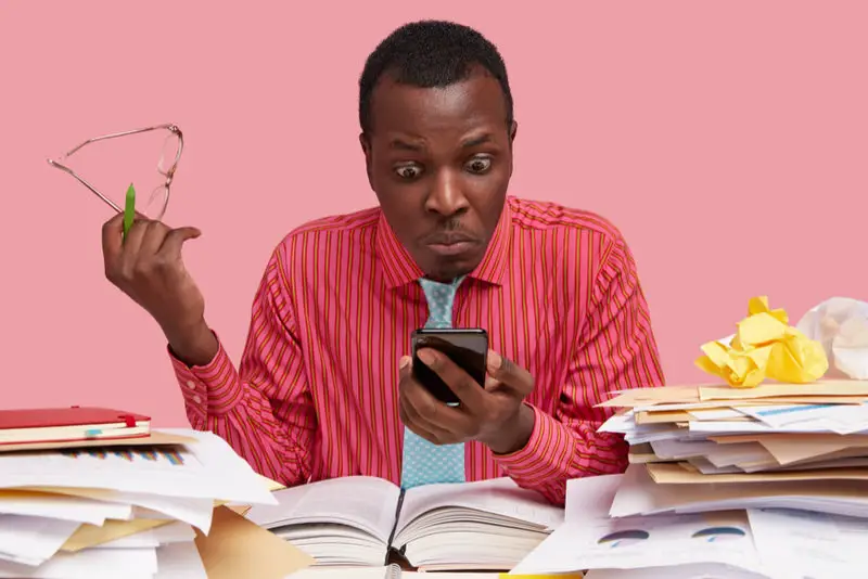 A young man is trying to research in books and on his phone to see if accepting personal checks from his employer is legal.