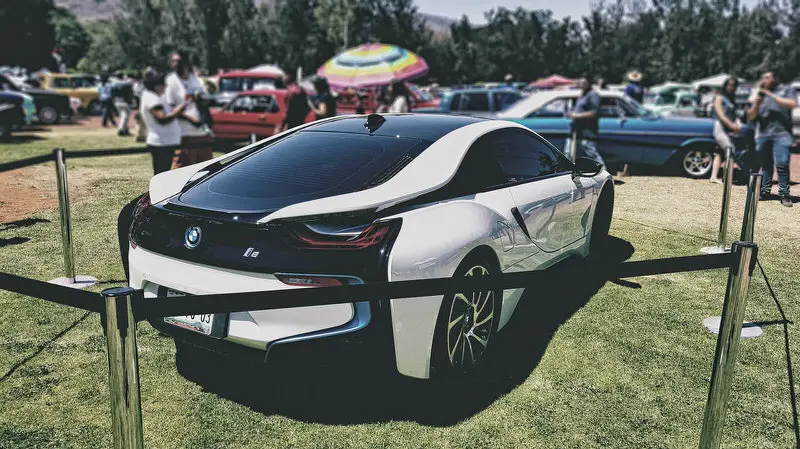 A new BMW i8 is parked at a car show for others to check out.