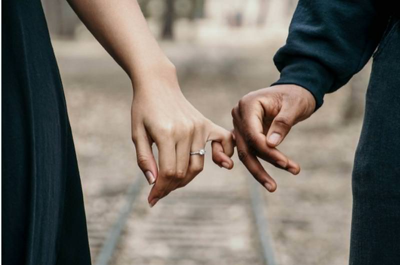 A couple are taking a picture after the woman was recently proposed to by the man