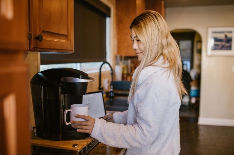 A woman who works from home is making coffee while working