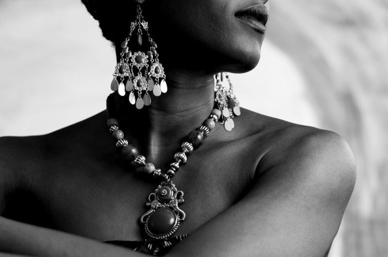A young woman is showing off her vintage earrings and necklace
