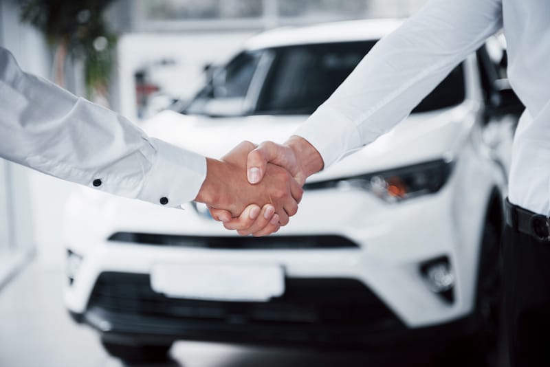 A young man is trading his car in for a different model, using his positive equity on the first car as a down payment for the new car.