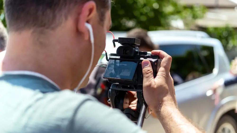 A young man is recording footage from a wedding for a video