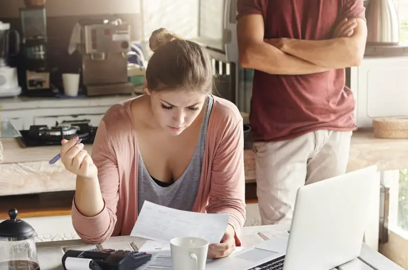 A married couple is looking over paperwork, trying to figure out which life insurance policy is best for them.