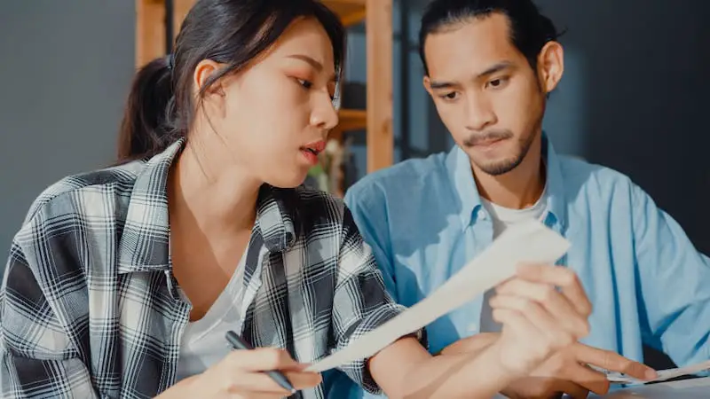 A young couple is reviewing their termite bond agreement