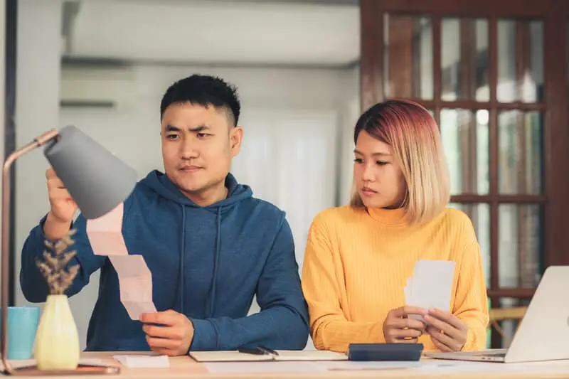 A young couple are looking over their finances together at home.